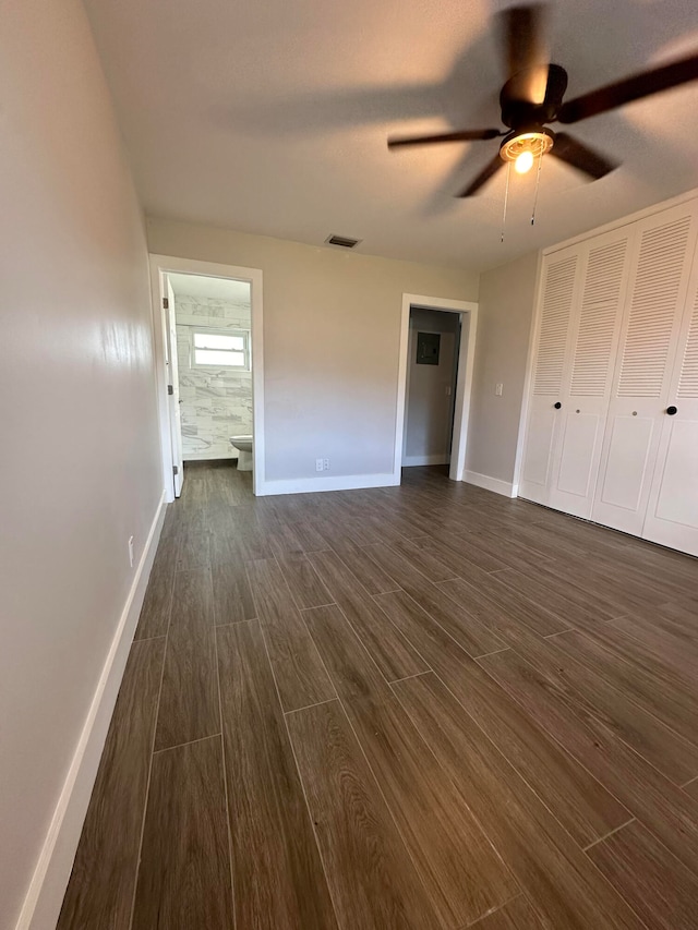 unfurnished bedroom featuring dark hardwood / wood-style flooring, ceiling fan, and ensuite bathroom