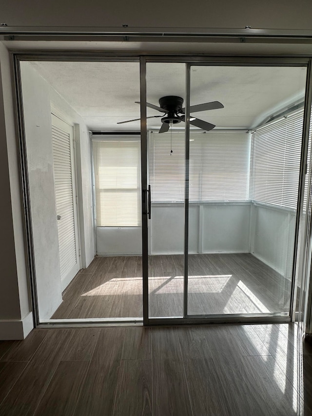 unfurnished sunroom featuring ceiling fan