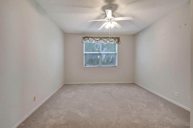 carpeted spare room featuring ceiling fan and a textured ceiling