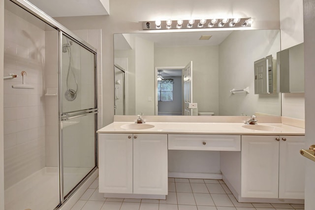 bathroom with vanity, tile patterned flooring, toilet, and a shower with door