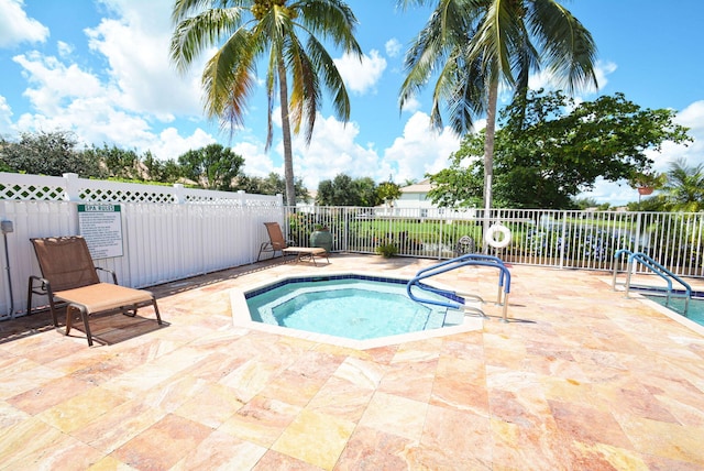 view of swimming pool with a hot tub and a patio area