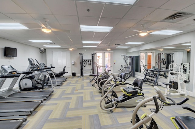 workout area featuring a drop ceiling, ceiling fan, and light colored carpet