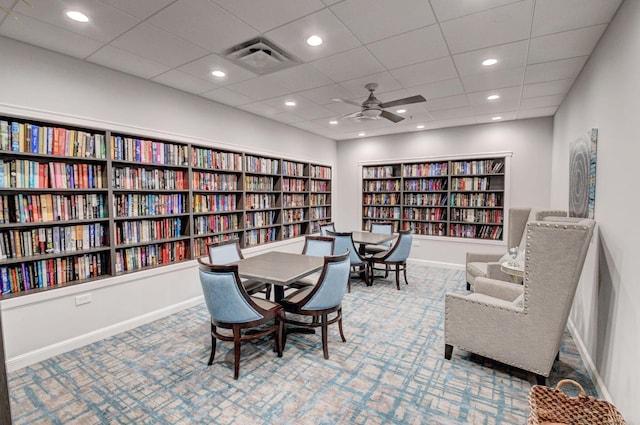 carpeted office with a paneled ceiling