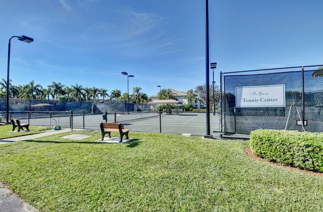 view of tennis court with a yard