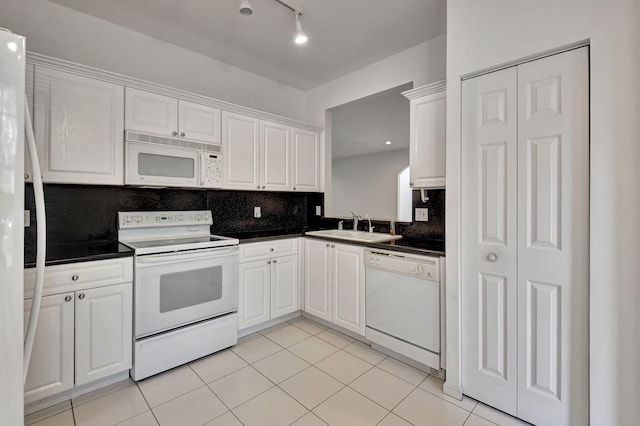 kitchen with white cabinets, sink, tasteful backsplash, and white appliances