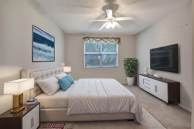 bedroom with light carpet, ceiling fan, and a textured ceiling