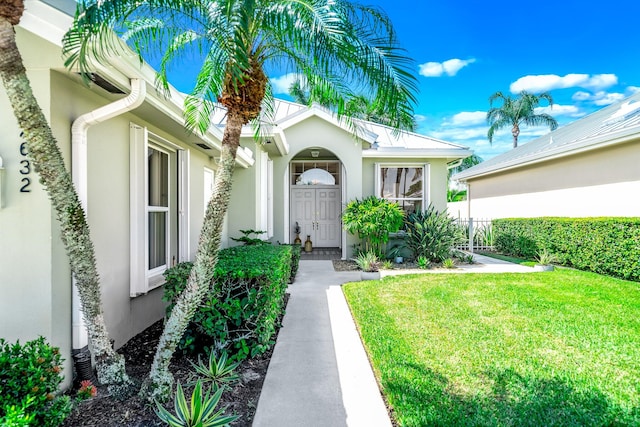 entrance to property with a lawn