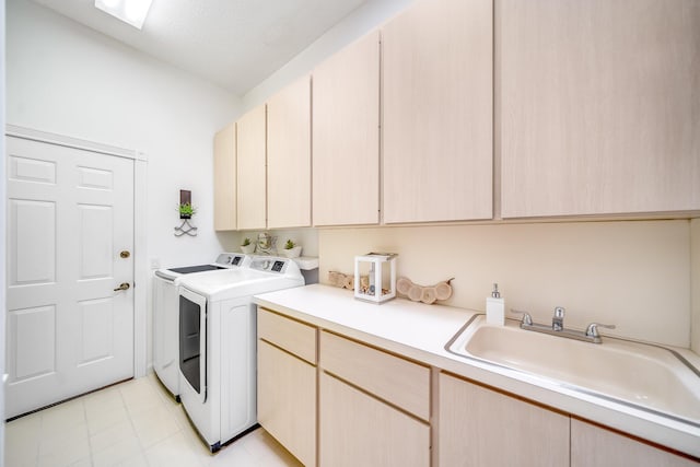 laundry room featuring cabinets, washing machine and clothes dryer, and sink