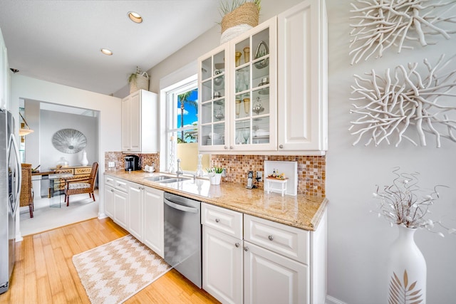 kitchen featuring light wood-type flooring, white cabinetry, appliances with stainless steel finishes, and backsplash