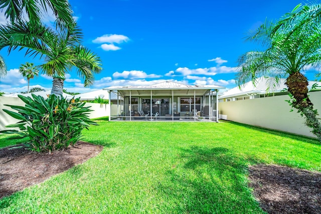 back of property with a sunroom and a lawn