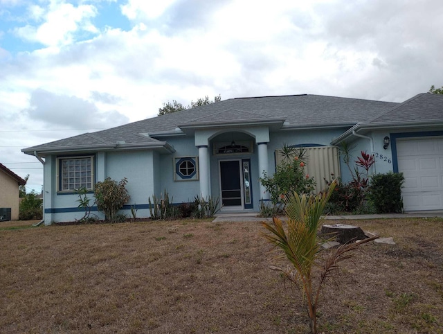 single story home with a front yard and a garage