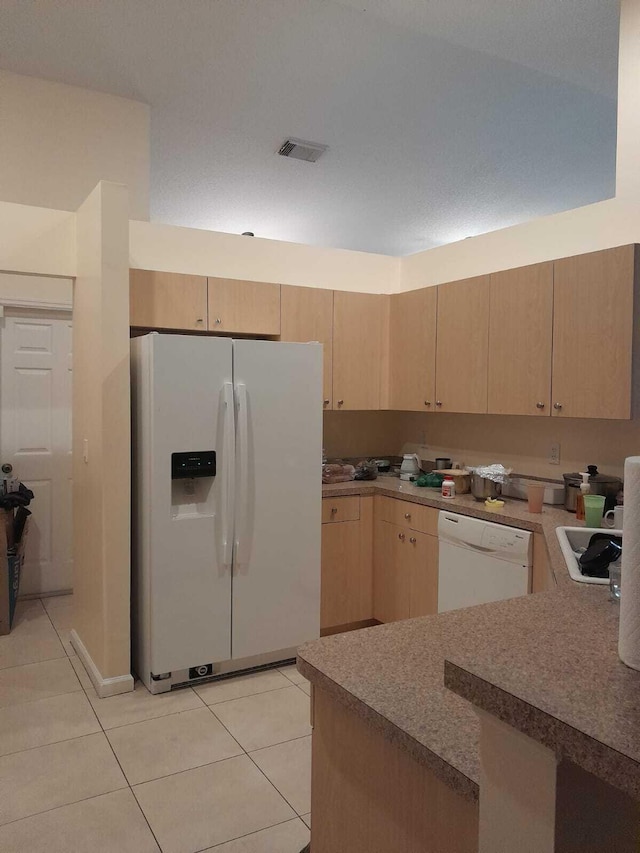 kitchen with white appliances, light brown cabinets, and light tile patterned floors