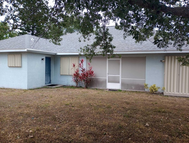 rear view of property featuring a yard