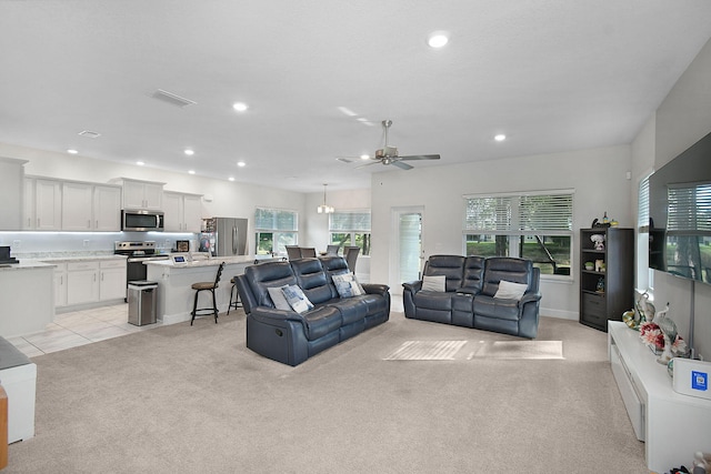 living room with ceiling fan, light colored carpet, and a healthy amount of sunlight