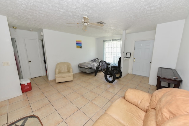 tiled living room featuring ceiling fan and a textured ceiling