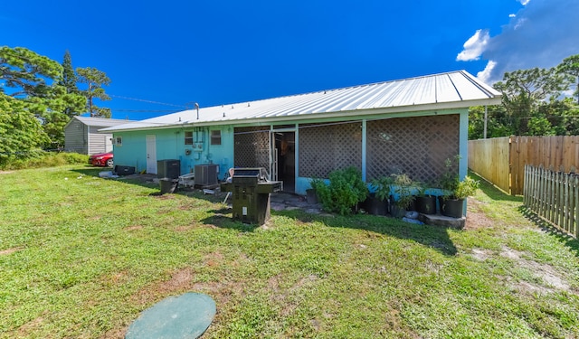 back of house featuring cooling unit and a yard