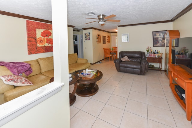 living room with ornamental molding, ceiling fan, light tile patterned floors, and a textured ceiling