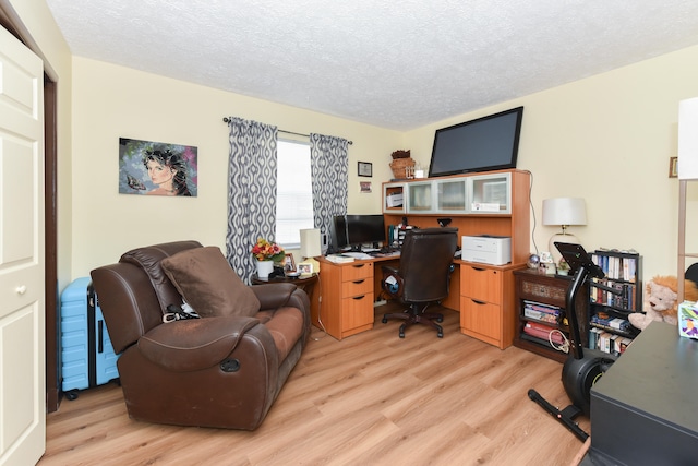 office area with light hardwood / wood-style flooring and a textured ceiling