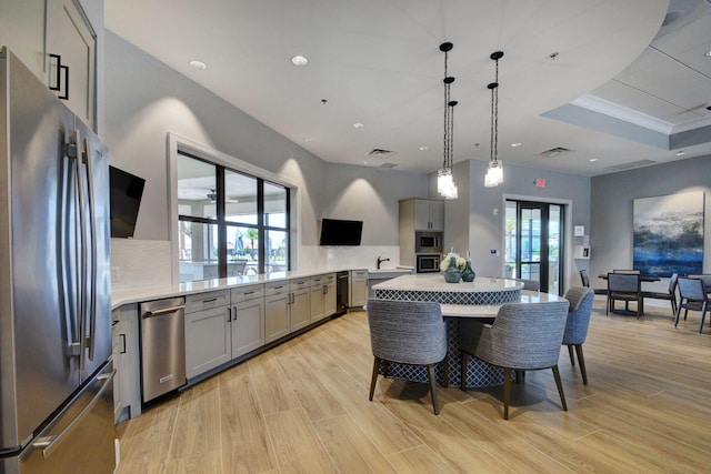 kitchen with stainless steel appliances, plenty of natural light, light hardwood / wood-style floors, and gray cabinetry