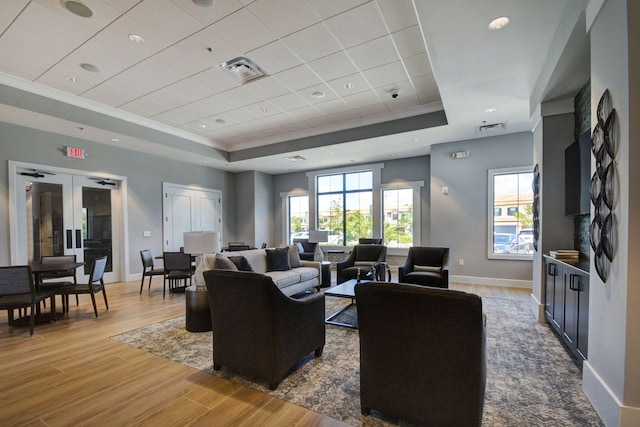 living room with wood-type flooring and a tray ceiling