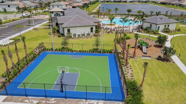 view of basketball court featuring a lawn, a playground, and a fenced in pool