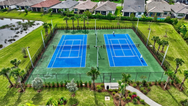 view of tennis court featuring a water view