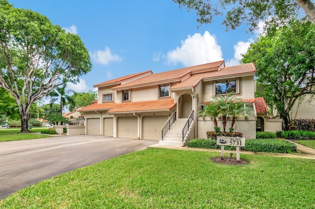 mediterranean / spanish home with a garage and a front lawn