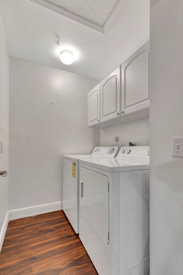 laundry area featuring separate washer and dryer, dark hardwood / wood-style floors, and cabinets