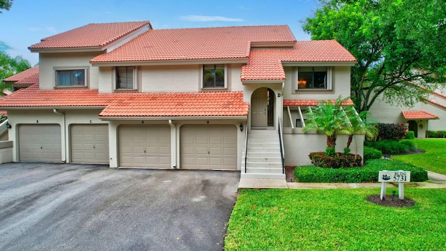 mediterranean / spanish house with a front lawn and a garage