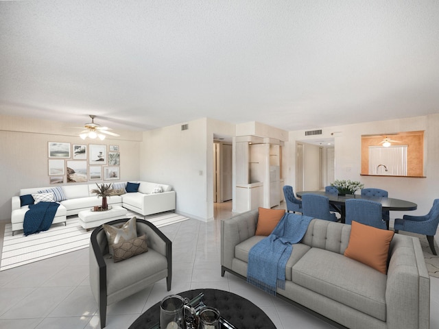 living room featuring ceiling fan, a textured ceiling, and light tile patterned floors