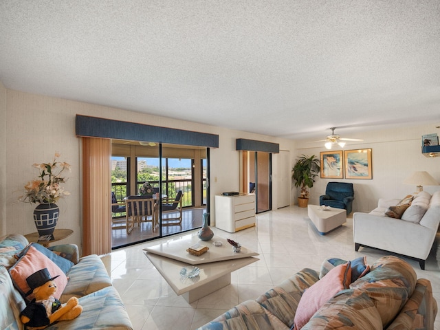 living room featuring ceiling fan, a textured ceiling, and light tile patterned floors