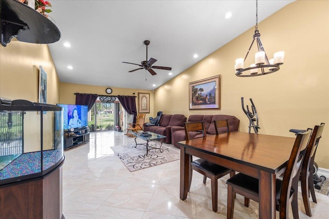 dining space featuring ceiling fan with notable chandelier and vaulted ceiling