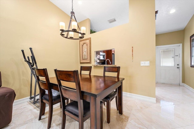 dining area with an inviting chandelier, lofted ceiling, and a textured ceiling