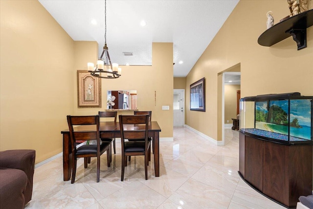 dining room with high vaulted ceiling and a notable chandelier