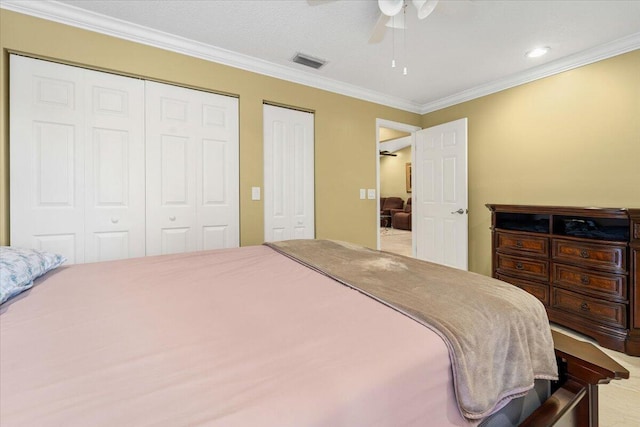 bedroom featuring ceiling fan, multiple closets, and ornamental molding