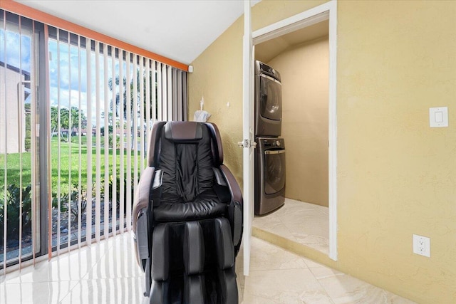 interior space featuring light tile patterned flooring, stacked washer and dryer, and vaulted ceiling