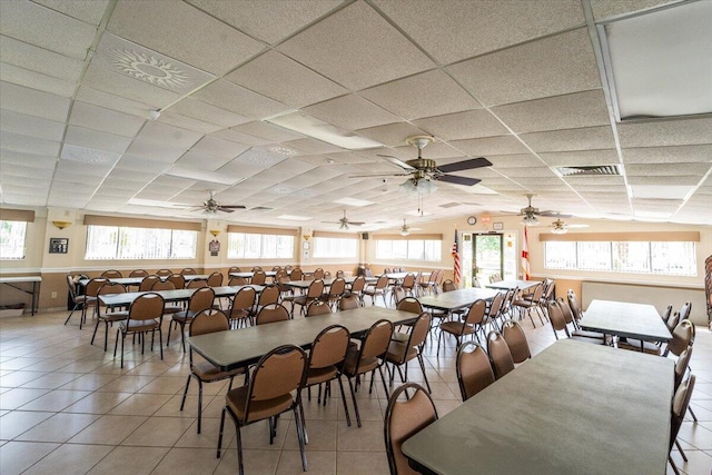 tiled dining space featuring a drop ceiling