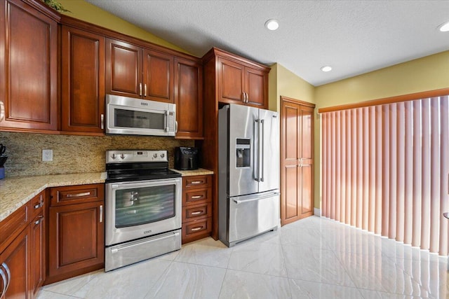 kitchen with light stone countertops, stainless steel appliances, backsplash, and vaulted ceiling