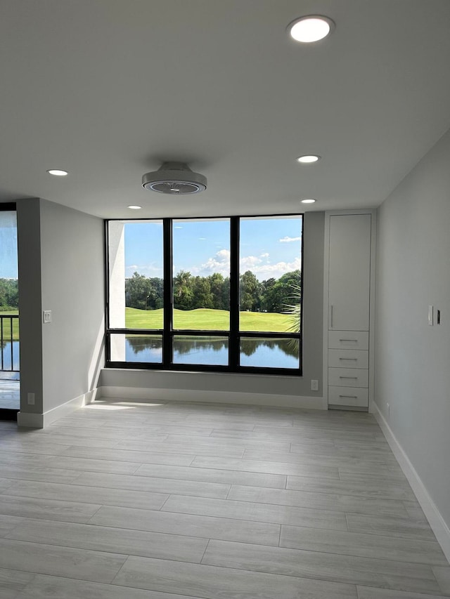 spare room featuring light hardwood / wood-style floors and a water view