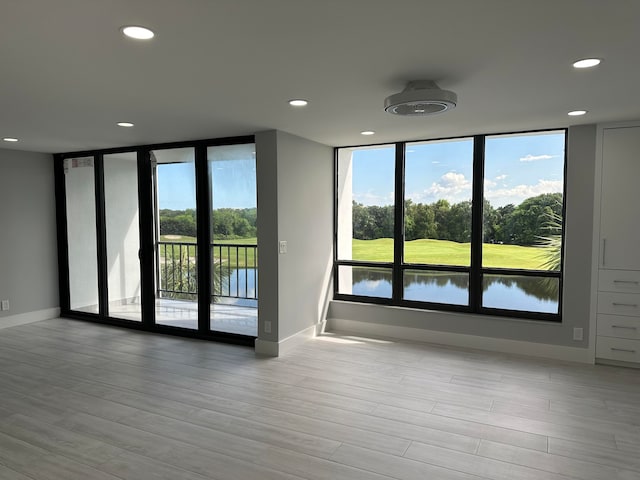 empty room with light hardwood / wood-style flooring and a water view