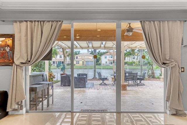 doorway to outside featuring crown molding, ceiling fan, and a wealth of natural light