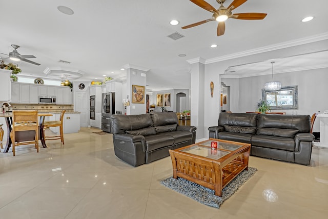 tiled living room featuring crown molding and ceiling fan with notable chandelier