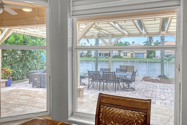 doorway with a water view, ceiling fan, and a wealth of natural light