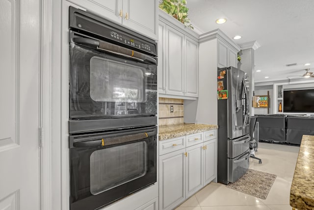 kitchen with stainless steel fridge, double oven, white cabinets, and light tile patterned flooring