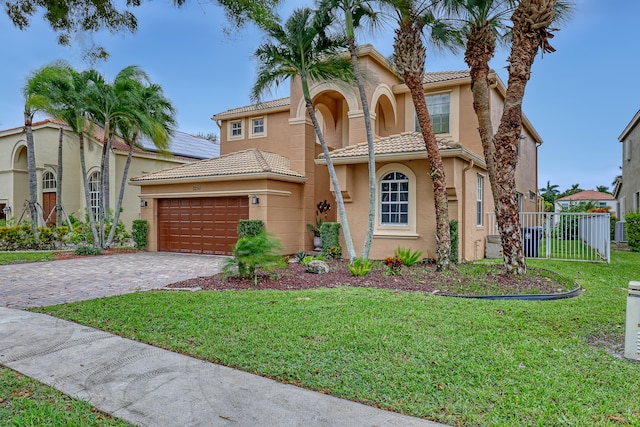 mediterranean / spanish-style home featuring a front yard and a garage