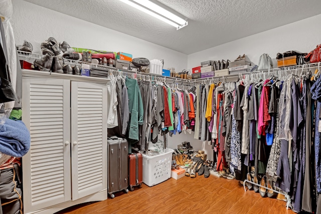 walk in closet with hardwood / wood-style flooring