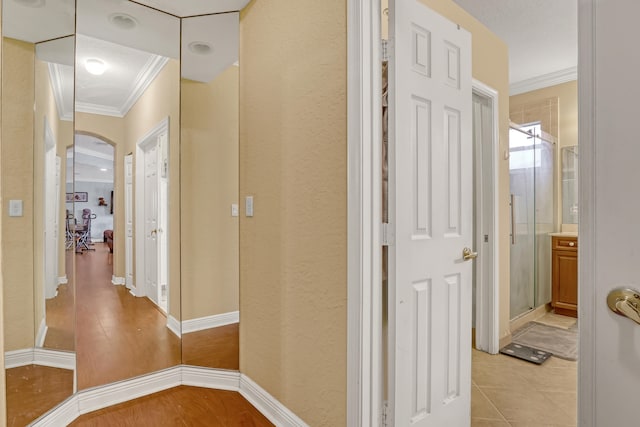 hallway with light hardwood / wood-style floors and ornamental molding