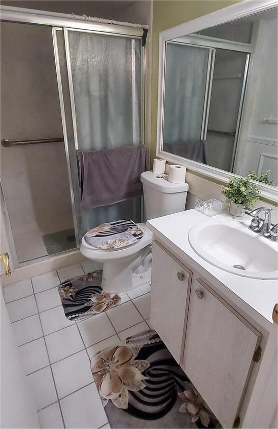 105 Lake Pine Cir Unit B-1, Greenacres, FL 33463 - full bath featuring vanity, tile patterned floors, toilet, and a shower stall