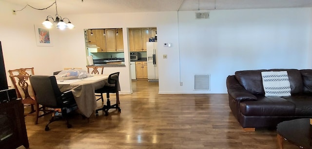 dining space featuring dark hardwood / wood-style floors, a notable chandelier, and sink