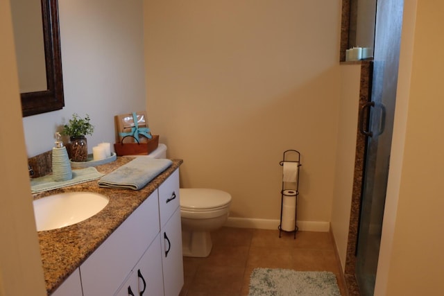 bathroom featuring tile patterned flooring, vanity, toilet, and a shower with door